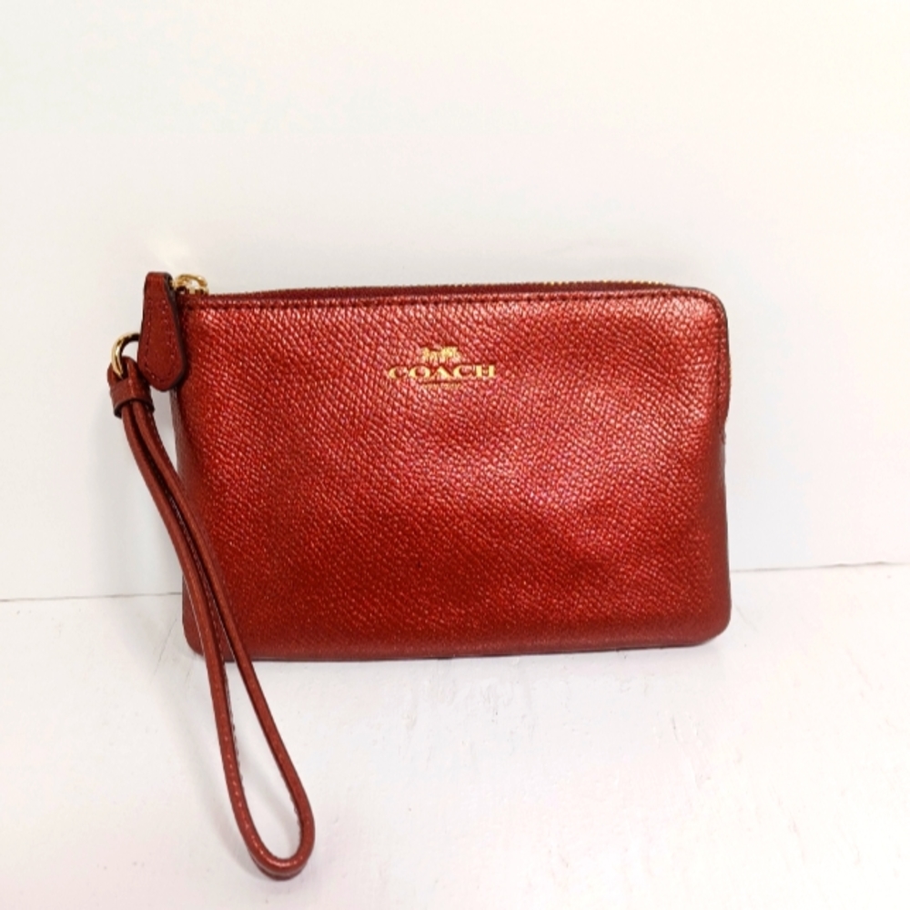 Coach Wristlet Metallic Pebbled Raspberry in color.